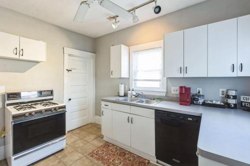 a kitchen with white cabinets and a black dishwasher at 446 Large 3 bedroom with Hot Tub in Lakewood