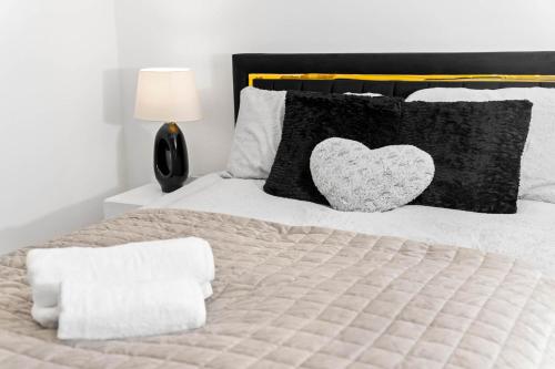 a bedroom with a bed with a heart pillow at Harmony House 3 Bedroom New Build for Families, Contractors, Black Country Museum Sleeps 6 in Tipton