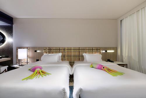 two beds in a hotel room at Veranda Resort Pattaya - MGallery by Sofitel - SHA Extra Plus in Jomtien Beach