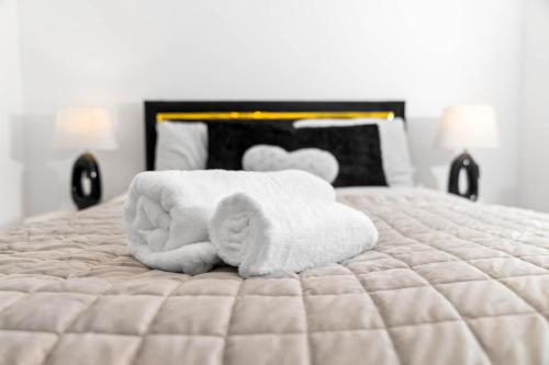 a pile of towels sitting on top of a bed at Harmony House 3 Bedroom New Build for Families, Contractors, Black Country Museum Sleeps 6 in Tipton