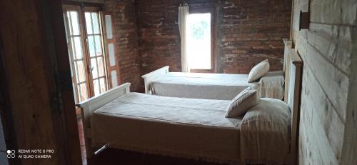 two beds in a room with two windows at El buho in Roldán