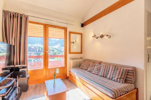 un salon avec un canapé et une fenêtre dans l'établissement Résidence Le Cervin - Résidence LE CERVIN N°612 MAE-7601, à La Plagne Tarentaise