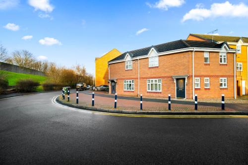 a brick building with blue and white posts on the street at Harmony House 3 Bedroom New Build for Families, Contractors, Black Country Museum Sleeps 6 in Tipton