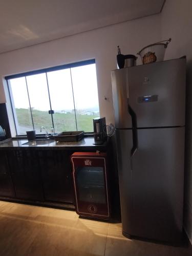 a kitchen with a stainless steel refrigerator and a sink at Casa de Charme Camargos in São João del Rei