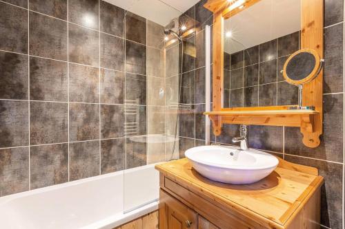 une salle de bain avec un lavabo, un miroir et une baignoire dans l'établissement Résidence Le Damier - Appartement 3 pièces pour 6 personnes de 52m² MAE-0761, à La Plagne Tarentaise