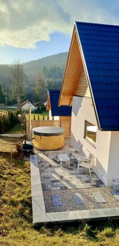 a house with a blue roof and a patio at Słoneczny Stok in Małastów