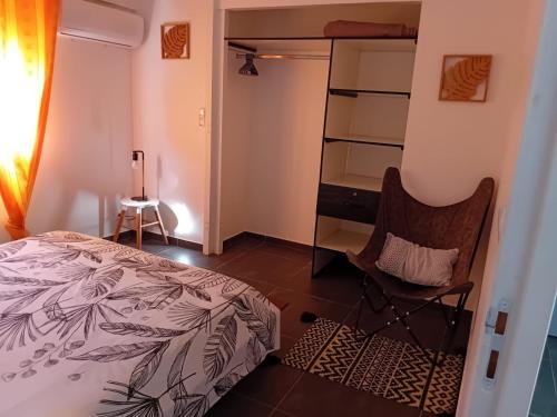 a bedroom with a bed and a desk and a chair at Villa Anj'any DESHAIES - 5 minutes à pieds de la plage in Deshaies