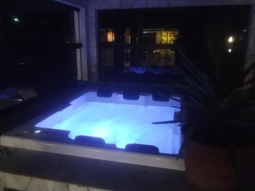 a large swimming pool with chairs in it at night at Casa de Charme Camargos in São João del Rei