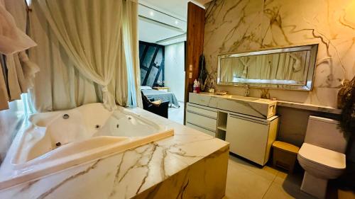 a bathroom with a tub and a sink and a mirror at Loft dos sonhos cobertura in Boa Vista