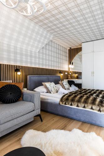 a bedroom with a large bed and a couch at APART Rogatek Szlachetny Pod Giewontem in Kościelisko
