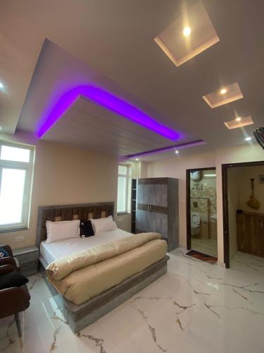 a bedroom with a large bed with purple lighting at Harmony Heights in Shimla