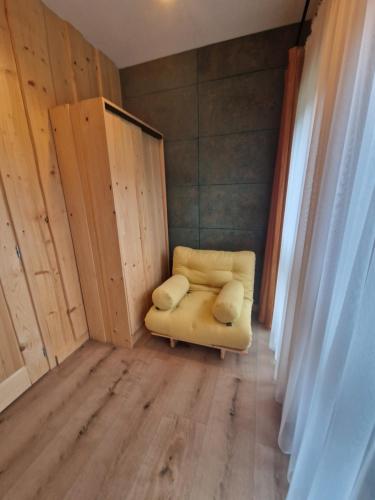 a small room with a yellow couch in the corner at Chata Braci Warchały in Warchały