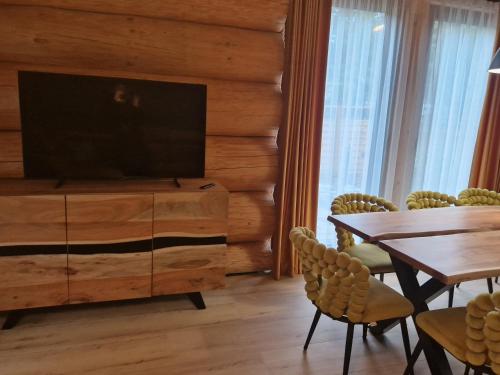 a living room with a television and a table and chairs at Chata Braci Warchały in Warchały