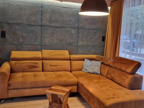 a brown leather couch in a living room with a table at Chata Braci Warchały in Warchały