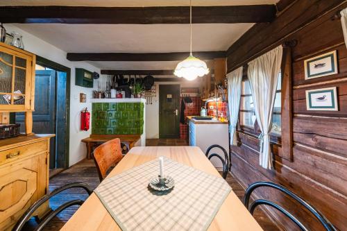 a dining room with a table and a kitchen at Chalupa V Tajchách in Rokytnice nad Jizerou