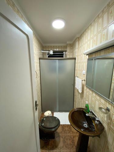 a bathroom with a black toilet and a sink at Apartamento Vista da Praia Espetacular! in São Vicente