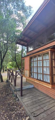a wooden house with a porch and a wooden deck at Centro Recreacional Maderos de San Juan in Concepción