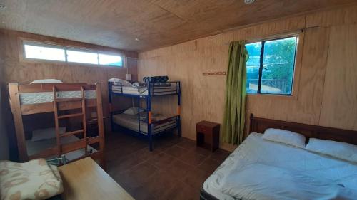 a small room with a bed and a window at Centro Recreacional Maderos de San Juan in Concepción
