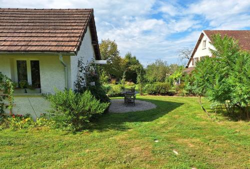 a garden with a bench and a house at ESTUVI, une pause nature dans le Jura in Chemenot
