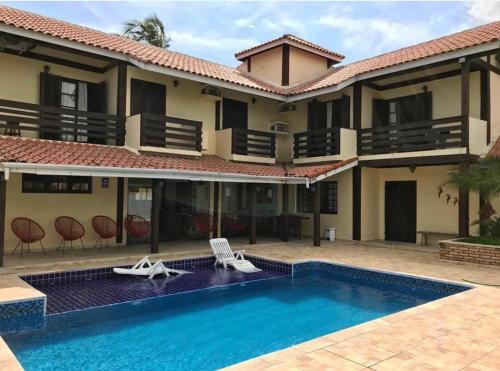 an image of a house with a swimming pool at Pousada Vitória Régia - Hotel Costeira in São Sebastião