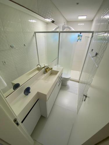 a white bathroom with a sink and a shower at Casa Ampla na Brava in Itajaí