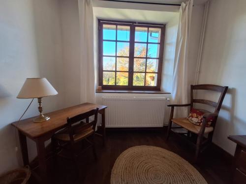 a room with a table and chairs and a window at ESTUVI, une pause nature dans le Jura in Chemenot