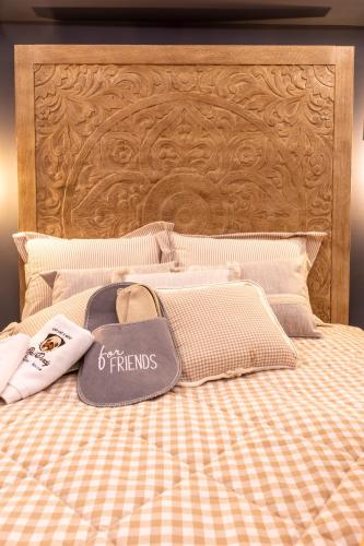 a bed with a wooden headboard and pillows on it at Rock Dandy La Maison de l'Ours - Nymfaio in Nimfaíon