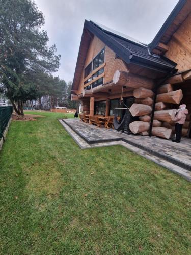a log cabin with a porch and green grass at Chata Braci Warchały in Warchały