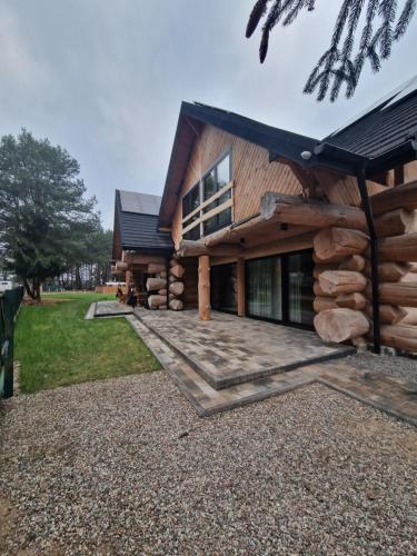 a log cabin with a large driveway in front of it at Chata Braci Warchały in Warchały