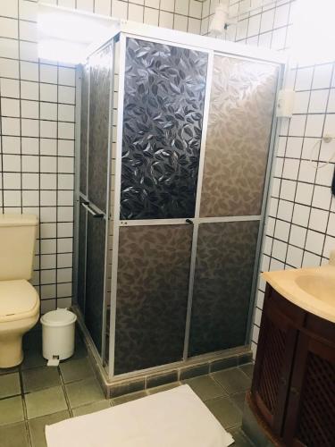 a shower stall in a bathroom with a toilet at Pousada Bella Maré in Goiana