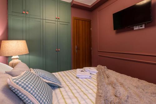 a bedroom with a bed with a tv on the wall at Rock Dandy La Maison de l'Ours - Nymfaio in Nimfaíon