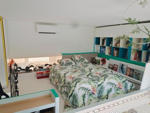 - une chambre avec un lit à motifs tropicaux dans l'établissement Loft atypique, au calme, à Montpellier