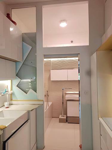 une cuisine avec des armoires blanches et un évier dans l'établissement Loft atypique, au calme, à Montpellier