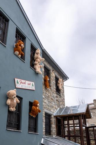 a bunch of stuffed teddy bears in the windows of a building at Rock Dandy La Maison de l'Ours - Nymfaio in Nimfaíon