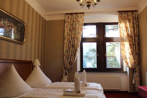 a hotel room with a bed and a window at Schlosshotel Stecklenberg in Thale