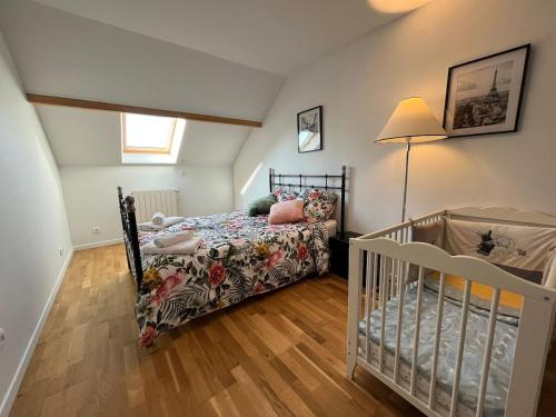 ein kleines Schlafzimmer mit einem Kinderbett und einem Babybett in der Unterkunft Family home between Paris and Disneyland in Noisy-le-Grand