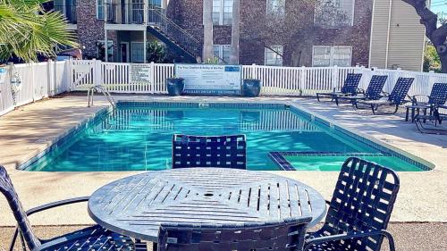 a table and chairs next to a swimming pool at Cozy and Quiet, with Easy Access & Private Garage in Corpus Christi