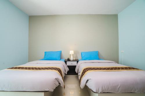 two beds sitting next to each other in a room at Sritrang Place in Hat Yai