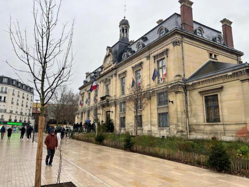 a person walking in front of a building at Charming Stay in Saint-Ouen