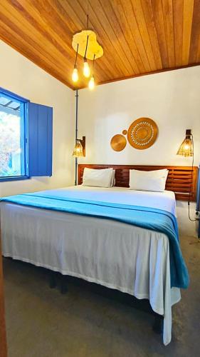 a bedroom with a large bed with blue sheets at Tapiri Pousada - Rota Ecológica dos Milagres in São Miguel dos Milagres