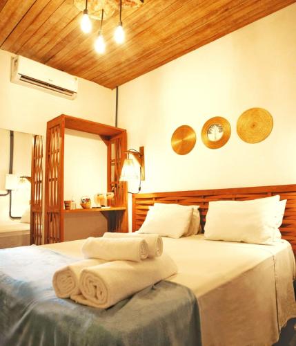 a bedroom with a bed with towels on it at Tapiri Pousada - Rota Ecológica dos Milagres in São Miguel dos Milagres