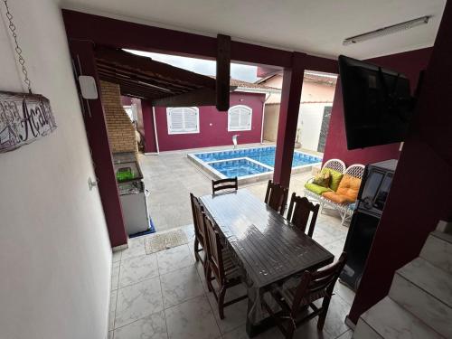 a dining room with a table and a swimming pool at Casa no Centro de Bertioga com Piscina in Bertioga
