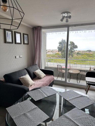 a living room with a couch and a glass table at la serena 1 dormitorio in La Serena