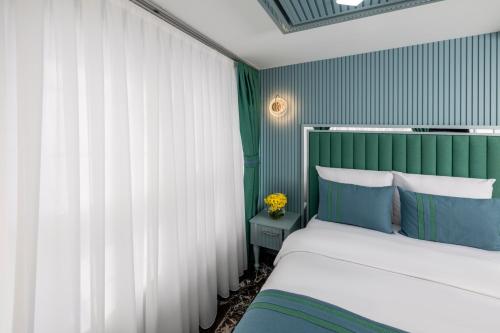 a bedroom with a bed with green and white curtains at Santa Rio Gold Taxim Hotel in Istanbul