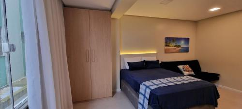 ein kleines Schlafzimmer mit einem Bett und einem Schrank in der Unterkunft Jk LOFT à beira-mar de CAPÃO DA CANOA, com ar condicionado split in Capão da Canoa