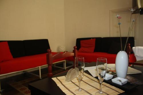 a living room with red couches and a table with wine glasses at La Chiave di Volta in Ragusa
