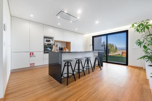 a kitchen with a counter and stools in a room at Esperança Terrace in Braga