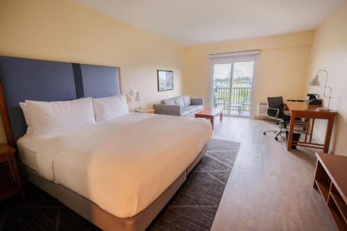 a hotel room with a large bed and a desk at SEVEN Sebring Raceway Hotel in Sebring
