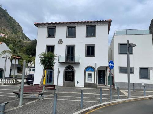 a white building with a bench in front of it at CGD São Vicente Apartments in São Vicente