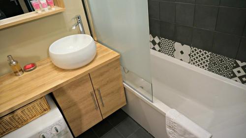 a bathroom with a sink and a toilet and a tub at Little Suite - Westhoek in Lille